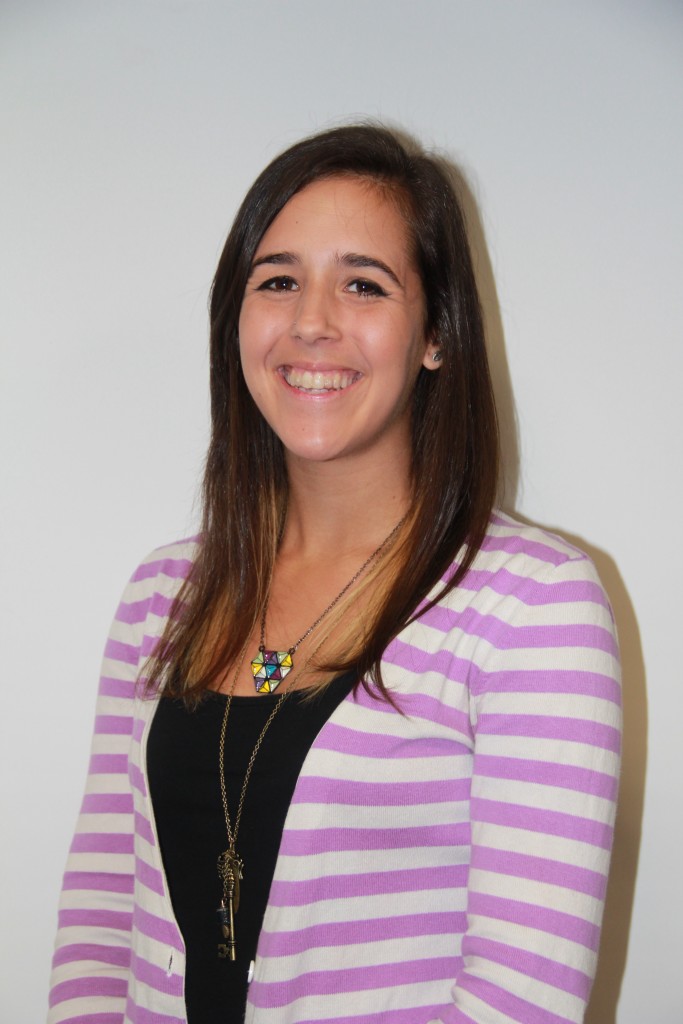 Dawn smiling wearing a pink and white striped cardigan and blackshirt