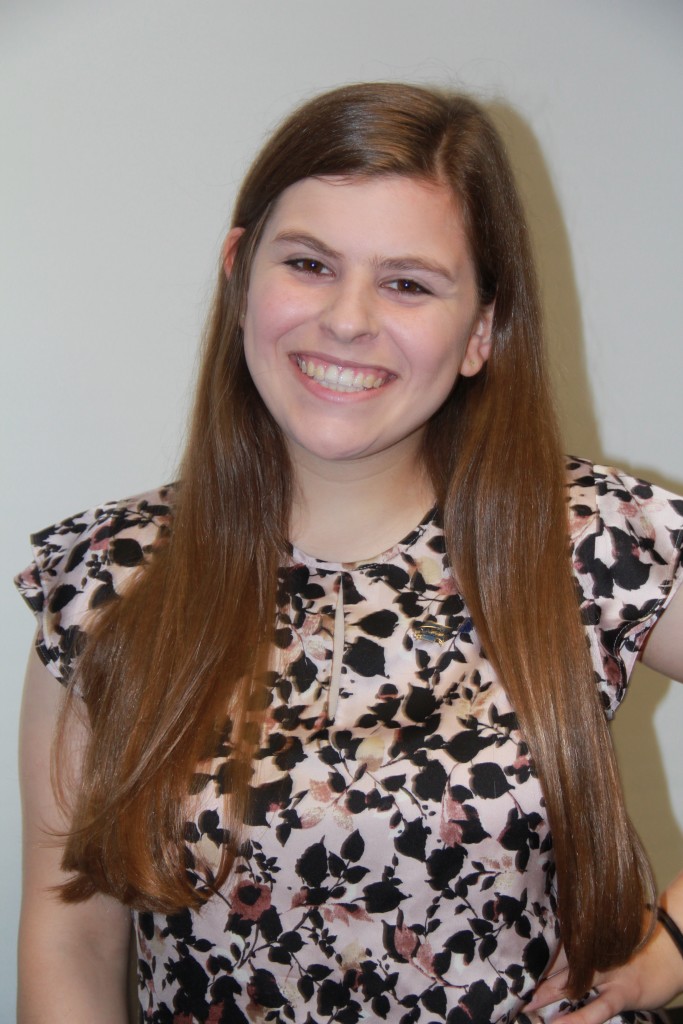 Rachel smiling wearing a brown and white speckled top